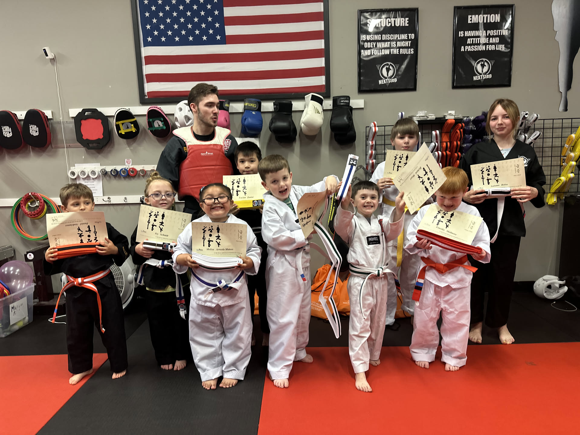 Kids celebrating with new belts and certificates after a belt test at NEXTStep Martial Arts in Gettysburg